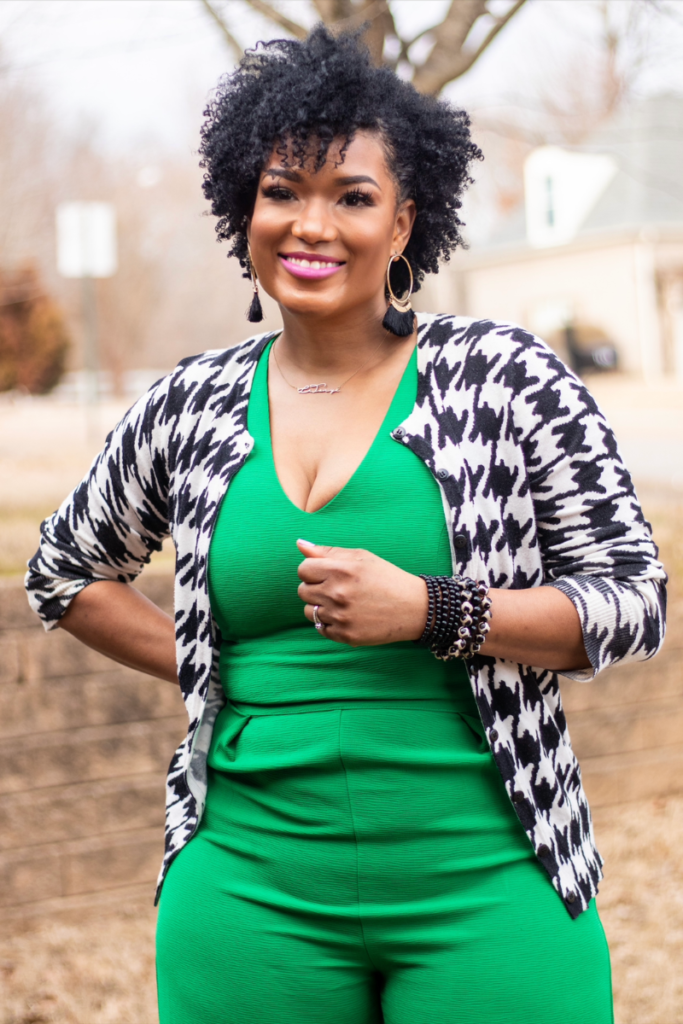 defined curls on twa wearing green jumpsuit and houndstooth cardigan