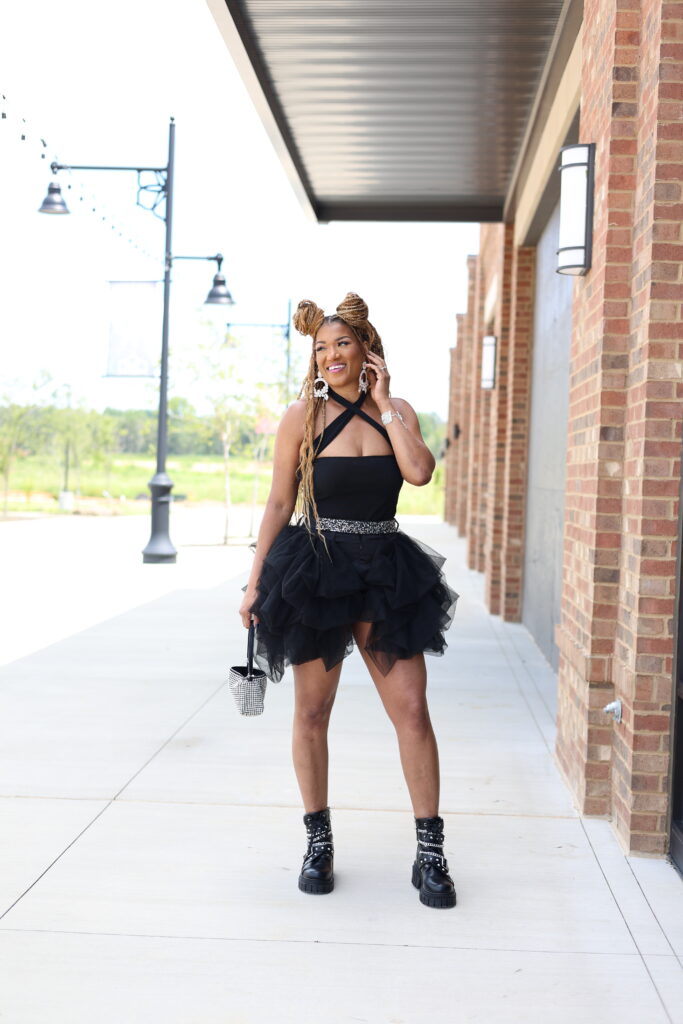 what to wear to a summer concert black bodysuit black tutu shorts black boots with chain detail